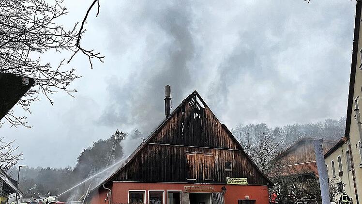 Die Feuerwehr löscht den Brand in der Brauerei neben dem Gasthaus (r.) in Thuisbrunn.