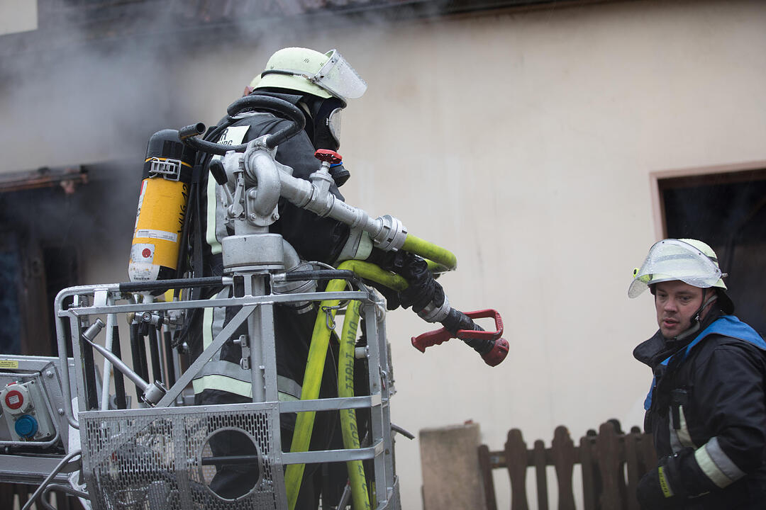 Brand in Doppelhaushälfte: Anderer Gebäudeteil in Mitleidenschaft gezogen - Bewohner leicht verletzt – Feuerwehr muss Dachstuhl öffnen, um Glutnester zu bekämpfen