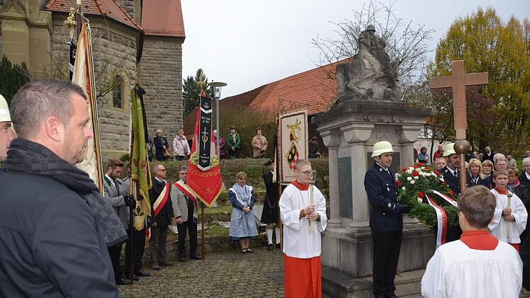 Im Beisein der Freiwilligen Feuerwehr und einem guten halben Dutzend Fahnenabordnungen der Ortsvereine legte Bürgermeister Toni Schick am Kriegerdenkmal in Reiterswiesen einen Kranz nieder. Foto: Peter Rauch