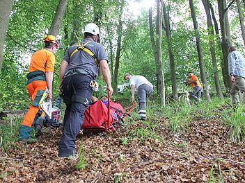 Der "verletzte" Waldarbeiter wird auf der Gebirgstrage mit Seilen den steilen Hang zum Rettungsfahrzeug (oben auf dem Waldweg) hoch gezogen.  Fotos: Friedwald Schedel