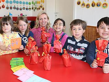 Was in Geschenkpapier verpackt ist, wird noch nicht verraten, aber auf eine CD zum Mitsingen können sich die Eltern der Kinder im Kliegl-Kindergarten schon freuen. Im Bild ist Erzieherin Dina Kuhnen mit (von links) Lilli, Helene, Zeinab, Lukas und Emmanuil zu sehen. Fotos: Ralf Ruppert