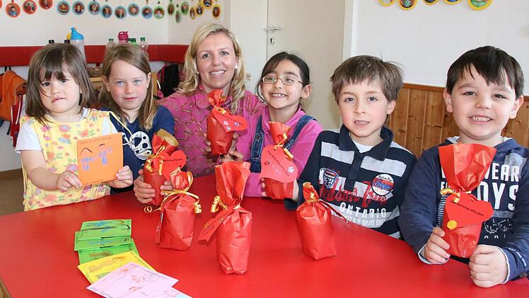 Was in Geschenkpapier verpackt ist, wird noch nicht verraten, aber auf eine CD zum Mitsingen können sich die Eltern der Kinder im Kliegl-Kindergarten schon freuen. Im Bild ist Erzieherin Dina Kuhnen mit (von links) Lilli, Helene, Zeinab, Lukas und Emmanuil zu sehen. Fotos: Ralf Ruppert