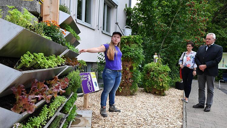 Sarah Helmert erklärt das vertikale System (l.) und den Pflanzturm (r.) im Demonstrationsgarten. Foto: Ronald Rinklef