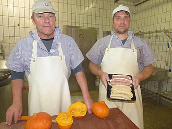 Die Metzgermeister Peter (links) und Marc Wehrfritz arbeiten auf Hochtouren, um die Bratwürste für den Pegnitzer "Bartwurstgipfel" zu machen.  In der Hand von Marc Wehrfritz oben die klassischen groben Bändelbratwürste, unten die Kürbisbratwurst. Foto: Thomas Weichert
