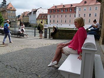 Projektleiterin Susanne Röhner auf der  Kirchenbank am Kranen mit Blick auf die Regnitz und das Alte Rathaus Foto: Marion Krüger-Hundrup