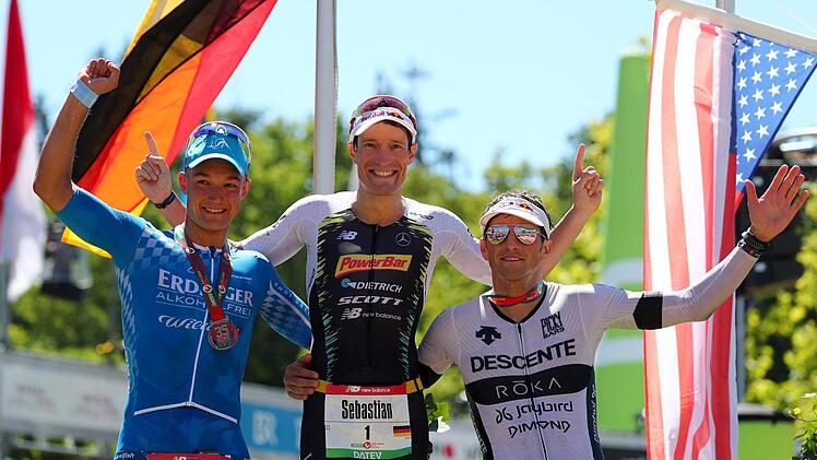 Das Podium der Männer mit dem Zweitplatzierten Andreas Dreitz aus Michelau (Lkr. Lichtenfels), Sieger Sebastian Kienle und dem drittplatzierten Amerikaner Jesse Thomas. Foto: Daniel Karmann/dpa