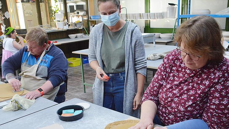 In der Kloster Manufaktur des Dominikus Ringeisenwerkes in Maria Bildhausen entstehen die "krummen Schüssel". Unser Bild zeigt Dorothee Würz im Gespräch mit einer Klientin beim Auswalzen. Foto: Hanns Friedrich
