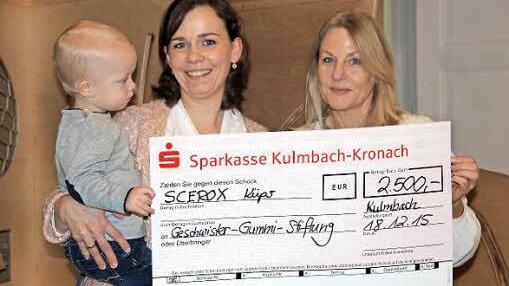Bildunterschrift: Sabrina Spielbühler-Stumpf übergibt mit Sohn Anton den Scheck der Firma Scerox in Höhe von 2.500 Euro an Regina Herath von der Geschwister Gummi Stiftung. Foto: Katharina Müller-Sanke