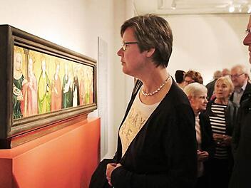 Gabi Borst und Stadtpfarrer Pater Markus Reis betrachten die Predella des sogenannten Münnerstädter Marientod-Altars. Das Gemälde ist derzeit als Leihgabe im Germanischen Nationalmuseum zu sehen und fand bei der Ausstellungseröffnung viel Beachtung. Foto: Heike Beudert