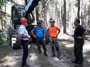PEFC-Auditor Wilfried Stech (links) besichtigt den Wald des Forstbetriebs Hammelburg der Bayerischen Staatsforsten. Im Gespräch mit Heiko Mann (Personalratsvorsitzender), Jürgen Müller (Forstwirtschaftsmeister und Einsatzleiter) und Uwe Baunach (Harvesterfahrer beim Unternehmen Dietmar Reith aus Heugrumbach) lässt er sich die Arbeit erklären.  Foto: Daniel Zippert