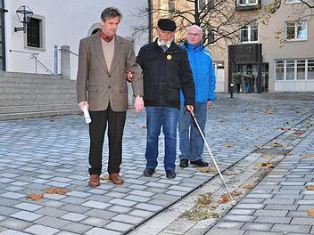 Die Rille in der Mitte des neu gestalteten Platzes zwischen Rathaus, Stadthalle und Landratsamt bildet laut Michael Schulz, Blinden- und Sehbehindertenbeauftragter des Seniorenbeirats in Haßfurt, eine wichtige Orientierungshilfe für Stockgänger. Unser Bild zeigt (von links) Wolfgang Braun, Leiter des technischen Bauamts, Michael Schulz und den Behindertenbeauftragten des Landkreises, Hans-Josef Hero.  Foto: Ulrike Langer