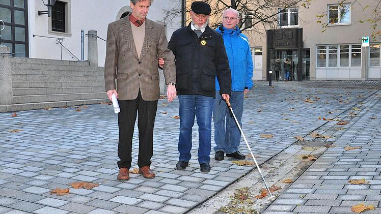Die Rille in der Mitte des neu gestalteten Platzes zwischen Rathaus, Stadthalle und Landratsamt bildet laut Michael Schulz, Blinden- und Sehbehindertenbeauftragter des Seniorenbeirats in Haßfurt, eine wichtige Orientierungshilfe für Stockgänger. Unser Bild zeigt (von links) Wolfgang Braun, Leiter des technischen Bauamts, Michael Schulz und den Behindertenbeauftragten des Landkreises, Hans-Josef Hero.  Foto: Ulrike Langer