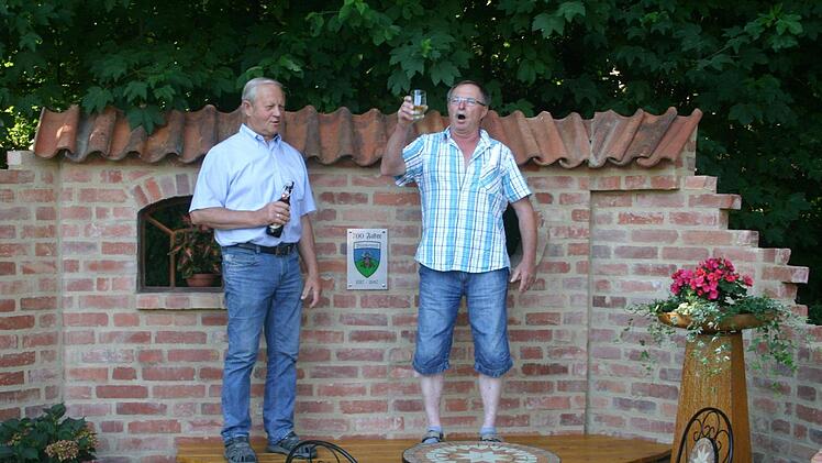 Ein Bierglas musste dran glauben, als Edgar Baetz (rechts) in Zimmermannsmanier Gottes Segen für das neu geschaffene Denkmal in Blumenrod erbat. Beim Richtfest attestierte Günther Steiner. Foto: Martin Rebhan