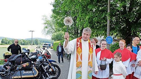 Pfarrer Andreas Hornung segnet die Motorräder beziehungsweise deren Fahrer.