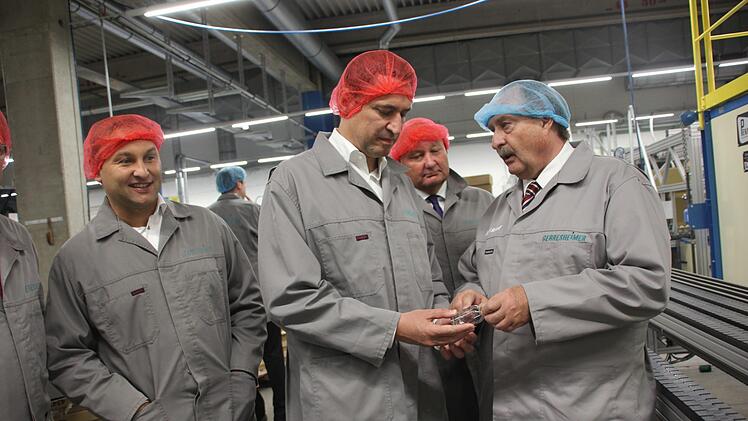 Werkleiter Bernd Hörauf (re.) zeigt Minister Georg Eisenreich ein fertiges Glasflakon. Mit im Bild Tettaus Bürgermeister Peter Ebertsch (2. v.re.) und  Landtagsabgeordneter Jürgen Baumgärtner.   Foto: Andreas Schmitt