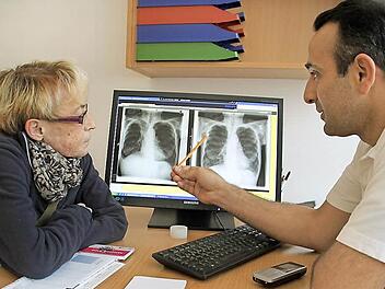 Der Lungenspezialist Joseph Alhanna zeigt Patientin Margarete Welsch anhand ihrer Röntgenbilder, wie sich ihr Lungenvolumen durch den Einsatz der Ventile verändert hat. Foto: Dagmar Besand