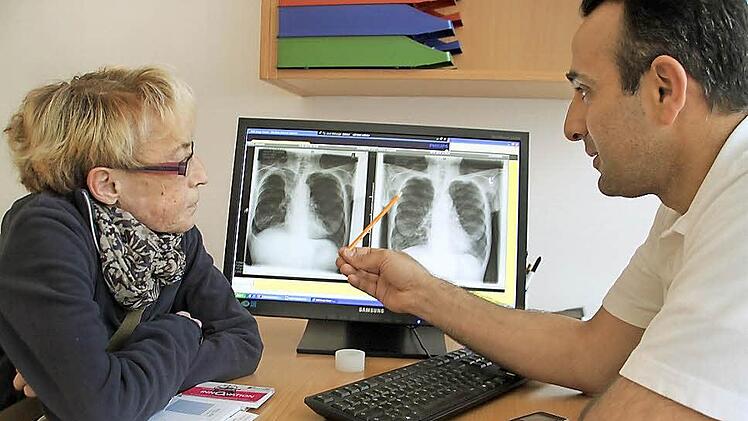 Der Lungenspezialist Joseph Alhanna zeigt Patientin Margarete Welsch anhand ihrer Röntgenbilder, wie sich ihr Lungenvolumen durch den Einsatz der Ventile verändert hat. Foto: Dagmar Besand