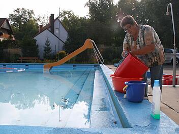 Die letzten Handgriffe der Saison 2013: Roswitha Ehmann reinigt die Mülleimer. Jetzt muss nur noch das Wasser abgelassen werden, dann kehrt für einige Monate Ruhe im Gnötzheimer Freibad ein. Foto: Daniela Röllinger