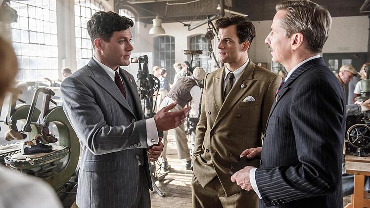 Adi Dassler (Ken Duken, l.), Rudolf Dassler (Torben Liebrecht, m.) und Josef Waitzer (David C. Brunners) in den Hallen ihrer Sportschuhproduktion.Foto: Willi Weber/RTL