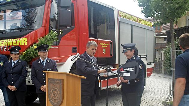 B&uuml;rgermeister Gerhard Wunder &uuml;bergibt sichtlich erfreut den Schl&uuml;ssel an Kommandantin Kerstin May. Foto: Susanne Deuerling