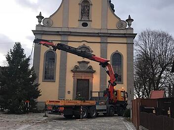 Die Freiwillige Feuerwehr Gro&szlig;wenkheim hat den Christbaum vor der Kirche aufgestellt.  Foto: Uwe Ankenbrand