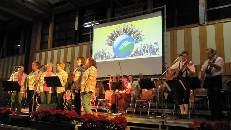 "Ein Lied zieht hinaus in die Welt": das Motto des Abends zum Mitsingen -  im Hintergrund der Erdball mit allen aktiven Musikern.