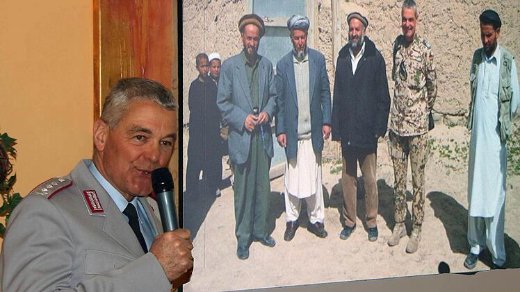 Zweimal Oberst i.G. Peter Utsch: Links bei seinem Vortrag im Erzählcafé im Haus St. Michael. Rechts auf einem per Beamer projizierten Bild zusammen mit einheimischen afghanischen Politikern.  Foto: Dieter Britz