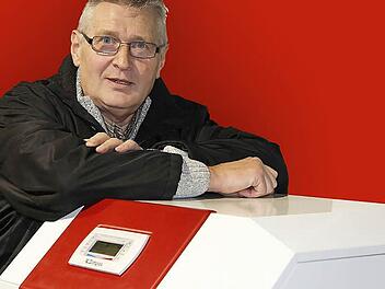 Erich Ramming lehnt im Schulungsraum seines ehemaligen Arbeitgebers Glen Dimplex in Kulmbach an einer Wärmepumpe. Foto: Matthias Litzlfelder