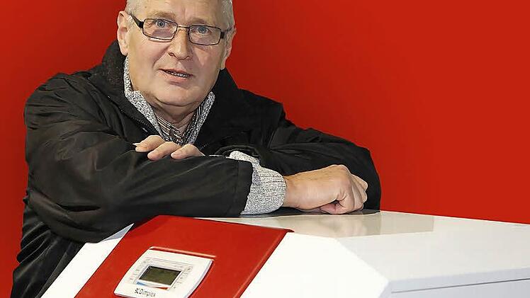 Erich Ramming lehnt im Schulungsraum seines ehemaligen Arbeitgebers Glen Dimplex in Kulmbach an einer Wärmepumpe. Foto: Matthias Litzlfelder