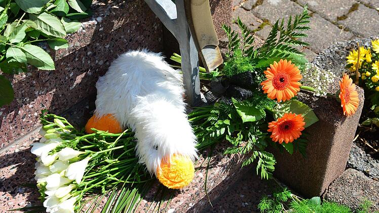 Thüringen, Altenfeld: Blumen als Zeichen der Trauer und ein Stofftier l. Dem 28 Jahre alten Familienvater aus Altenfeld (Ilmkreis) wird vorgeworfen, im Juni zwei seiner Söhne mit einem Küchenmesser getötet und einen weiteren Sohn schwer verletzt zu haben.