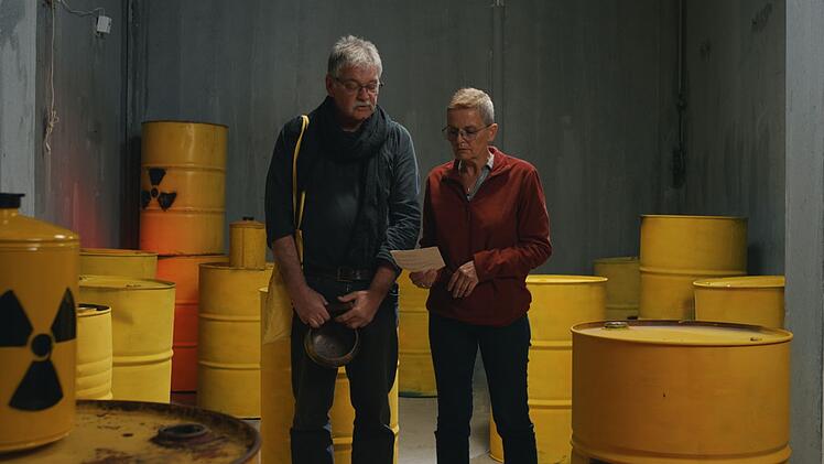 Die Anti-Atom-Aktivisten Tom und Carola lesen den Text einer Mahnwache aus dem Jahr 1990 vor. Seit Jahrzehnten halten sie wöchentlich Mahnwachen vor dem Kraftwerk Gundremmingen ab, um gegen die Kernkraft zu protestieren.