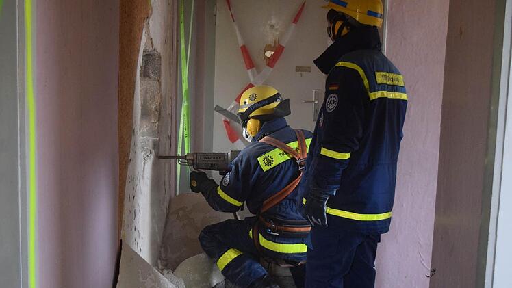 Wanddurchbruch: Mit einem elektrischen Aufbruchhammer verschaffen sich die Helfer durch die Wand Zugang zum einem ‚Verschlossenen Raum‘ Foto: THW/Daniel Schell