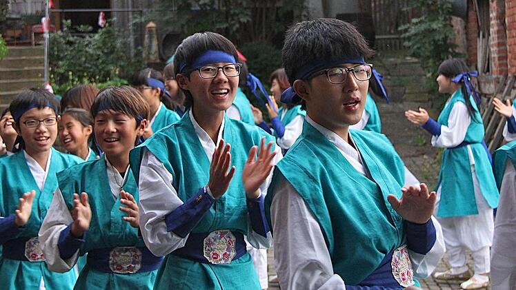 Singend, tanzend und klatschend zogen die jungen Koreaner die Zuschauer am Schreinersch-Haus in ihren Bann. Die Asiaten strahlten pure Lebensfreude aus, und so sprang der Funke der Völkerverständigung rasch über. Fotos: Gerd Schaar