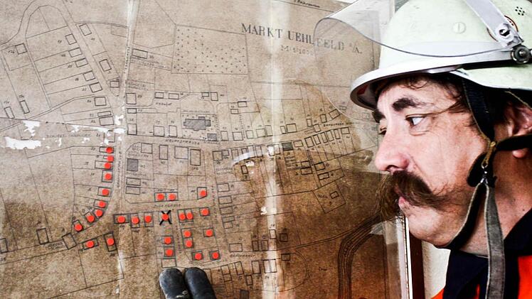 Kommandant Markus Kraft zeigt auf die rot markierten Grundstücke, die das Feuer heimgesucht hat. Der Plan stammt aus dem Jahr 1888.