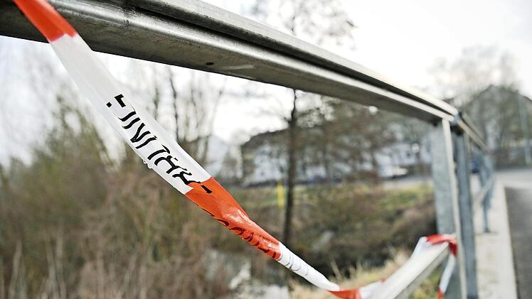 Schweinfurt: Polizeiabsperrband hängt an einer Brücke. Die Polizei hatte am Vorabend Chemikalien in einer Sozialunterkunft entdeckt (Gebäude im Hintergrund), die für den Bau von Rohrbomben geeignet gewesen wären. Foto: Nicolas Armer/dpa
