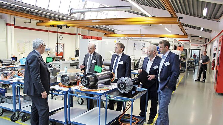 Geschäftsführer Claus-Peter Lehnert (links) erklärt Landrat Wilhelm Schneider, Maroldsweisachs Bürgermeister Wolfram Thein, Wirtschaftsförderer Michael Brehm und Büroleiter Michael Rahn die Funktionen der Weiss'schen Spindeln. Foto: Klaus Brose, Weiss Spindeltechnologie GmbH