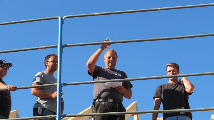 Bauarbeiter der Firma Raab und Zimmerer Meister Erik Thiel (mit Zettel)  in luftiger Höhe beim Richtspruch Foto: Monika Schütz