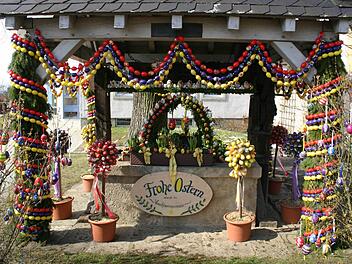 In der Osterzeit bunt geschmückt ist der Osterbrunnen vor der Hollfelder Stadtpfarrkirche. Fotos: Löwisch