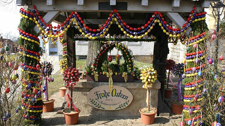 In der Osterzeit bunt geschmückt ist der Osterbrunnen vor der Hollfelder Stadtpfarrkirche. Fotos: Löwisch