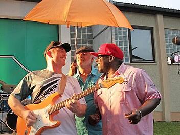 Gut beschirmt musizieren "Orange Shakers"-Sänger Larry Rayford (rechts) und Gitarrist Stefan Kratovil (links). Beim Auftritt in Unnersdorf brauchen sie keinen Regenschutz.  Foto: Stephan Stöckel