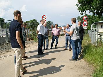Bis Ende des Jahres die neue Schleusenbrücke in Limbach endgültig für den Verkehrs freigegeben und die alte abgebrochen ist, muss es noch einmal eine Vollsperrung geben, erläuterte Jakob Kolbersberger vom Wasserstraßen-Neubauamt (Zweiter von rechts) dem Eltmanner Bauausschuss. Links entsteht der neue Übergang; die Stadträte stehen auf der Zufahrt zur bestehenden Brücke.  Foto: Sabine Weinbeer