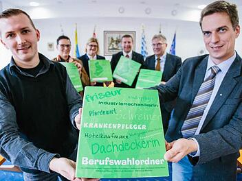 Stefan Mück (vorne links, stellvertretender Schulleiter der Pestalozzi-Schule) und Matthias Weber (Wirtschaftsbeauftragter der Montessori-Schule) präsentieren den Ordner. Daniela Wölfel (hinten, von links), Karin Elsel, Uli Förtsch und Uwe Dörfer waren bei der Übergabe dabei. (Foto: Hendrik Steffens)