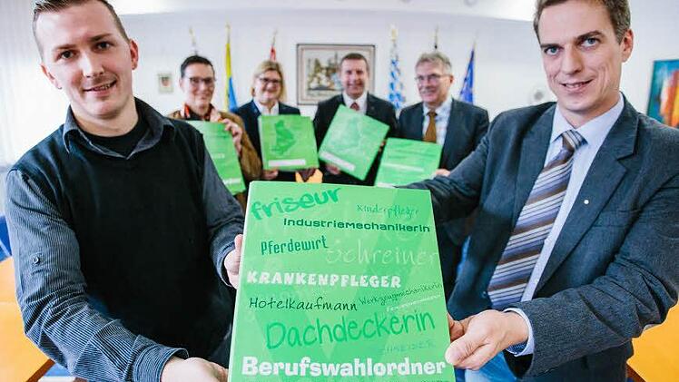 Stefan Mück (vorne links, stellvertretender Schulleiter der Pestalozzi-Schule) und Matthias Weber (Wirtschaftsbeauftragter der Montessori-Schule) präsentieren den Ordner. Daniela Wölfel (hinten, von links), Karin Elsel, Uli Förtsch und Uwe Dörfer waren bei der Übergabe dabei. (Foto: Hendrik Steffens)