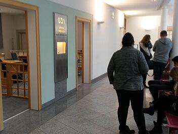 Zuhörer warten in einer Verhandlungspause vor dem Sitzungssaal im Bamberger Amtsgericht. Foto: jb