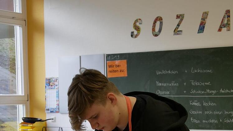 Sammy legt die Servietten ansprechend auf das Tablett, so wie es  die Lehrerin ihn lehrte. Foto: Manja von Nida
