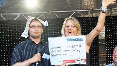 Regina Herath von der Geschwister-Gummi-Stiftung jubelt. Mit dem Geld können Ferienaktivitäten für Kinder finanziert werden. Links im Bild BR-Redaktionsleiter Alexander Müller.