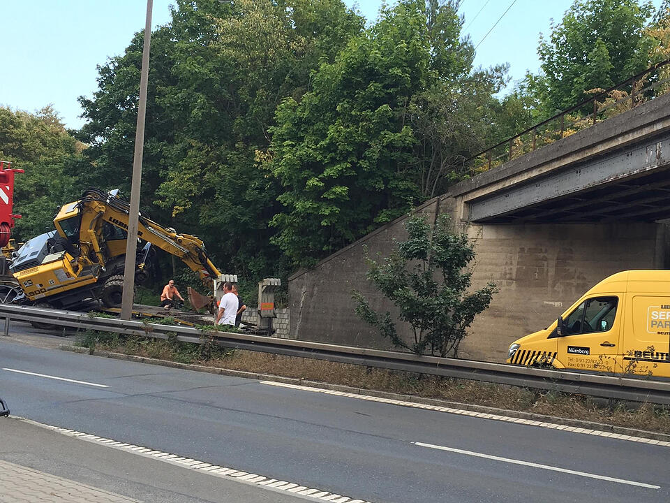 Am Montagnachmittag (10.08.2015) ereignete sich ein kurioser Unfall auf der Rothenburger Strasse in Oberasbach. Ein Lkw-Fahrer hatte offensichtlich die Höhe seines aufgeladenen Baggers unterschätzt. Als das Gespann unter einer Brücke hindurchfahren wollte, prallte der Ausleger der Baumaschine gegen das Bauwerk, wodurch der Bagger seitlich vom Lastwagen stürzte. Erst durch einen Kran konnte die havarierte Maschine wieder aufgeladen werden. Währenddessen musste die Straße komplett gesperrt werden.