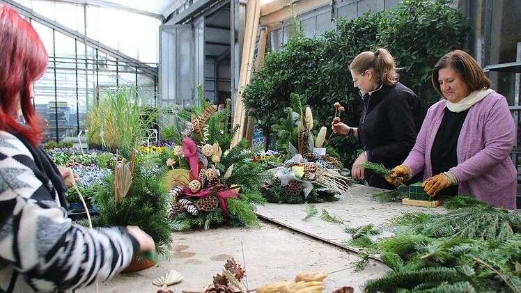 Helga Nusser (rechts) und ihre Mitarbeiterinnen der Gärtnerei Nusser haben vor Allerheiligen allerhand zu tun, damit die Gräber bepflanzt und geschmückt werden können. Knallbunte Gestecke gibt es aber nur auf Wunsch. Der Trend geht zu schlichten Farben und Naturtönen.  Foto: Jutta Rudel