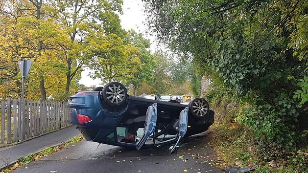 Auf dem Dach landete dieses Auto in der Egerlandstra&szlig;e. Die Fahrerin hatte die Kurve offenbar mit zu viel Schwung genommen. Foto: Susanne Will