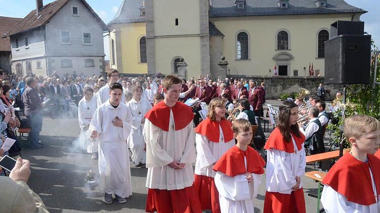 Ministranten und Geistliche beim Einzug zum festlich geschmückten Altarpodium. Im Hintergrund der Musikverein Glosberg und der Gesangverein "Liederkranz" Haig. Foto: Karl-Heinz Hofmann